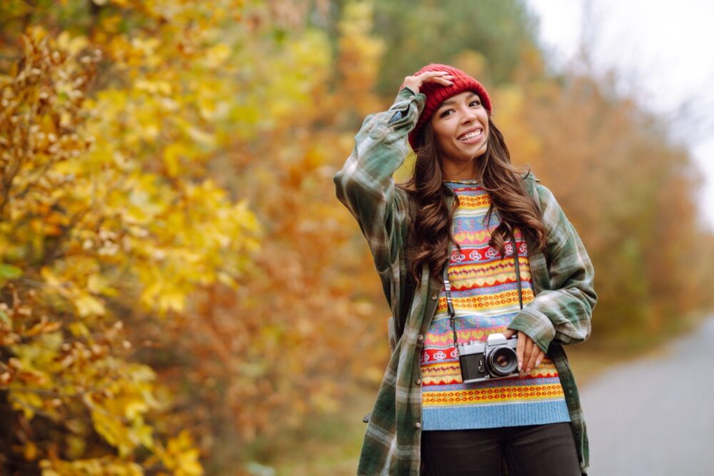 Prekrasna mlada žena fotografira se retro kamerom. Odmor, opuštanje, putovanja, lifestyle koncept